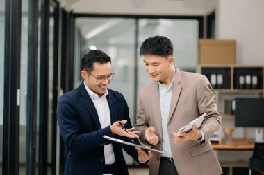 İki Asyalı işadamı ofiste yatırım projesini tartışıyor