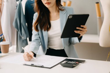 Modern stüdyoda tablet bilgisayar kullanan kadın moda tasarımcısı