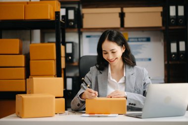 Küçük işletme KOBİ 'si kurun. Paket hazırlamak için çevrimiçi alışveriş siparişini alan Asyalı kadın.