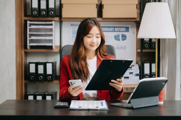 Confident Asian business expert attractive smiling young woman holding digital tablet  at desk in creative office