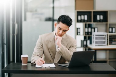 Olgun iş adamı yöneticisi dizüstü bilgisayarda çalışıyor, piyasa araştırması yapıyor, ofiste çalışıyor.