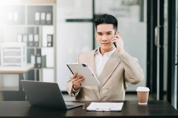 Mature businessman executive manager looking at digital tablet, watching online webinar training or having virtual meeting video conference, doing market research, working in office