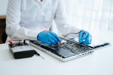 Elektronik teknisyen, ölçüm ve test, onarım ve bakım kavramları, atölyede kontrol ve yükseltme için bir voltaj ölçer kullanır 