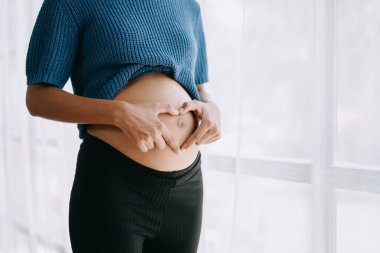 Hamile Afro-Amerikan kadın ev penceresinde beyaz arka plan boşluğunda