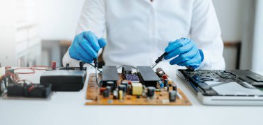 Elektronik teknisyen, ölçüm ve test, onarım ve bakım kavramları, atölyede kontrol ve yükseltme için bir voltaj ölçer kullanır 