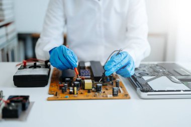 Elektronik teknisyen, ölçüm ve test, onarım ve bakım kavramları, atölyede kontrol ve yükseltme için bir voltaj ölçer kullanır 