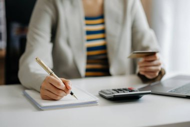 İnternet üzerinden alışveriş yapmak için kredi kartı olan iş kadını ve modern ofiste finans stratejisi 
