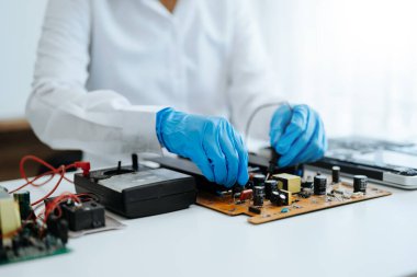 Elektronik teknisyen, ölçüm ve test, onarım ve bakım kavramları, atölyede kontrol ve yükseltme için bir voltaj ölçer kullanır 