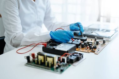 Elektronik teknisyen, ölçüm ve test, onarım ve bakım kavramları, atölyede kontrol ve yükseltme için bir voltaj ölçer kullanır 