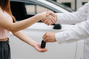 Otomotiv işi, araba satışı veya kiralık konsept. Otomobil galerisinde müşteri temsilcisi anlaşma yapıyor. 