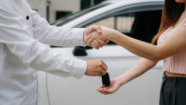 Otomotiv işi, araba satışı veya kiralık konsept. Otomobil galerisinde müşteri temsilcisi anlaşma yapıyor. 