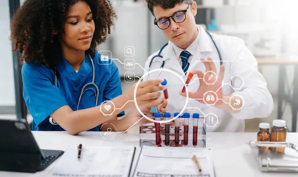 Doctor Talks With Professional Nurse or Surgeon, They looking at sample. Diverse Team of Health Care Specialists Discussing Test Result on desk in hospital