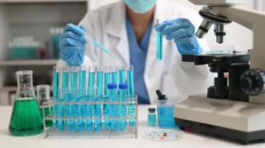 Bir tıp laboratuarında araştırma yapan bilim adamları, ön plandaki bir araştırmacı tıp laboratuvarında bir mikroskop kullanıyor..