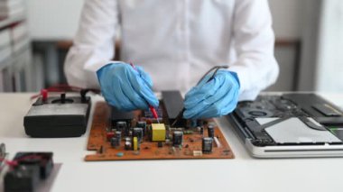 Elektronik teknisyen, elektronik mühendisliği, elektronik onarım, ölçüm ve test, onarım ve bakım kavramları. Dükkanda kontrol ve yükseltme için voltaj ölçer kullanır  
