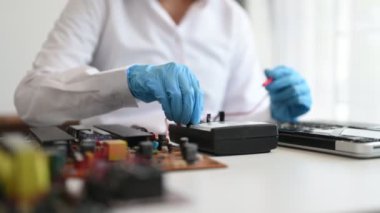 Elektronik teknisyen, elektronik mühendisliği, elektronik onarım, ölçüm ve test, onarım ve bakım kavramları. Dükkanda kontrol ve yükseltme için voltaj ölçer kullanır  