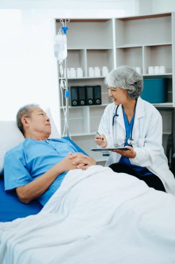 Doktor, Hasta Dinlenmesi 'ni Yatakta Kontrol Ediyor. Hastanede başarılı bir ameliyattan sonra iyileşen adamı kontrol ediyor.