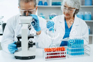 Laboratuvar ve çevre dostu bilim alanında çalışan iki Asya 'lı bilim adamı. Bilim insanları küresel ısınma ve sanal ikon ekranlı teknoloji için test örneklerini analiz ediyorlar