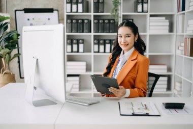 İş kadını ofis masasında dijital tableti finans raporu olarak kullanıyor. Ofiste analitik araştırma kavramı