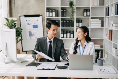 Ev ofisinde dizüstü bilgisayar kullanan iki Asyalı iş adamı.