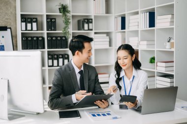 Ev ofisinde dizüstü bilgisayar kullanan iki Asyalı iş adamı.