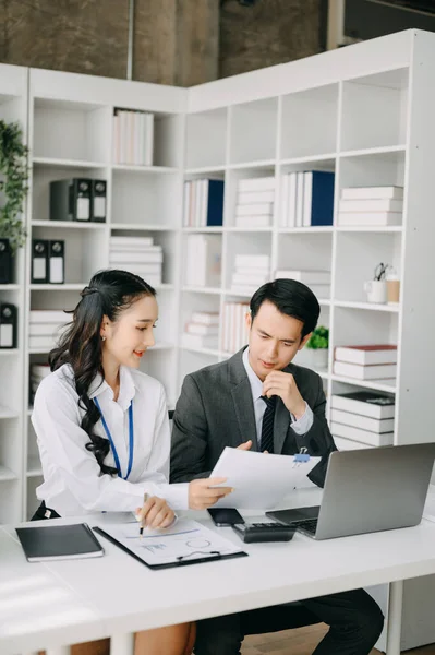 Ev ofisinde dizüstü bilgisayar kullanan iki Asyalı iş adamı.