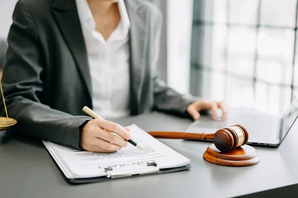 stock image justice and law concept. Male judge in a courtroom the gavel, working on laptop and digital tablet computer on white table