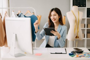 Atölyede dururken gülümseyen başarılı bir moda tasarımcısı. Stüdyoda çalışan güzel bir iş kadını.