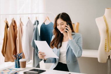 Atölyede dururken gülümseyen başarılı bir moda tasarımcısı. Stüdyoda çalışan güzel bir iş kadını.
