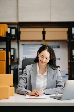 Küçük işletme KOBİ 'si kurun. Paket hazırlamak için çevrimiçi alışveriş siparişini alan Asyalı kadın.