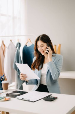 Atölyede dururken gülümseyen başarılı bir moda tasarımcısı. Stüdyoda çalışan güzel bir iş kadını.