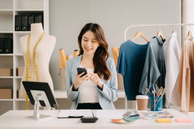 Atölyede dururken gülümseyen başarılı bir moda tasarımcısı. Stüdyoda çalışan güzel bir iş kadını.