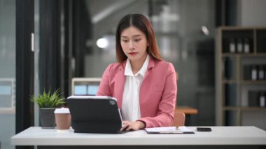 Ofiste tablet üzerinde çalışan Asyalı iş kadını 