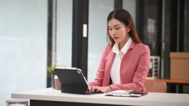 Ofiste tablet üzerinde çalışan Asyalı iş kadını 