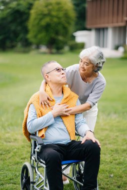 Asyalı son sınıf çifti iyi vakit geçiriyor. Parkta gülüyorlar ve gülümsüyorlar. Hoş yaşlı çift.