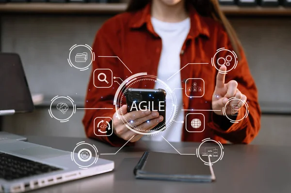 Agile development methodology concept. Businesswoman hands using smartphone with virtual screen. Agile icon on modern office, digital technology concept