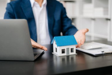 Ev ya da sigorta sözleşmesi alırken, bir sigorta acentesi ev kiralamak isteyenleri kalemle işaret ediyor.