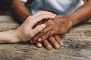 Hands of the old man and a woman hands close up.