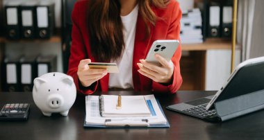 Akıllı telefondan online alışveriş yapmak için akıllı telefon ve kredi kartı kullanan iş kadını elleri 