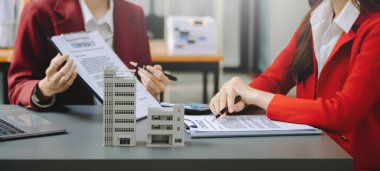  Kontrat imzalıyorum. Müşteri ve komisyoncu, kira sözleşmesi, başarılı bir anlaşma. Ofisteki masada oturan genç iş adamları.