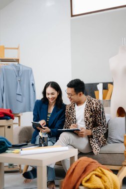 İki profesyonel tasarımcı, dijital tablet kullanarak mağazada son tasarımı tartışıyor ve buluşuyorlar. 