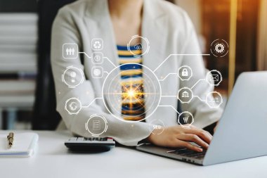 İş kadını elleri dizüstü bilgisayarda çalışıyor, VR simgesi diyagramı ise sabah ışığında ofiste.