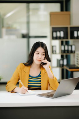 Ofis masasında dizüstü bilgisayarla çalışan kadın işkadını portresi.