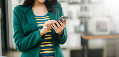 Akıllı telefon kullanan bir iş kadını. Bulanık arkaplanda yakın plan