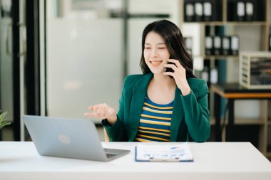 Güzel Asyalı kadın çalıştığı yerde dizüstü bilgisayar kullanıyor. İşine odaklan.