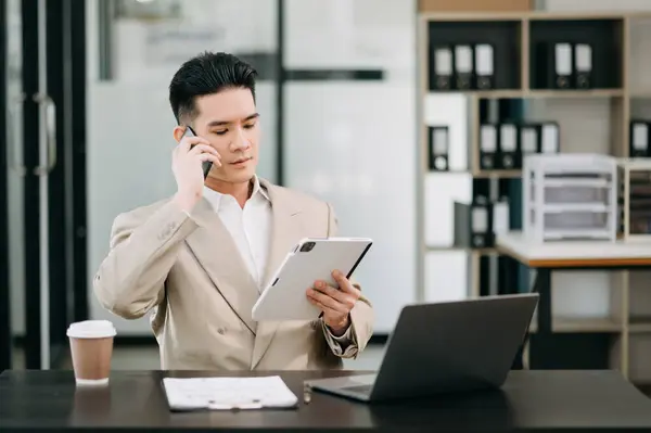 Mature businessman executive manager looking at digital tablet, watching online webinar training or having virtual meeting video conference, doing market research, working in office