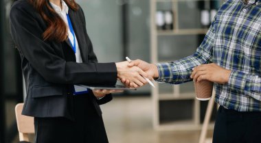 Ofisteki bir toplantıda el sıkışan iki kendinden emin iş adamı, başarı, anlaşma, selamlama ve ortaklık