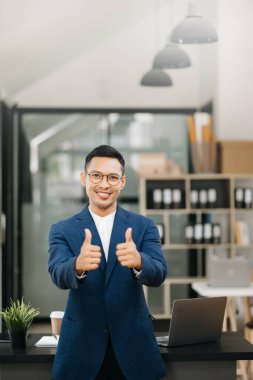 Genç ve çekici Asyalı İşadamı ofiste çalışıyor.