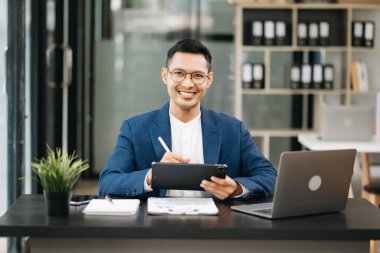 Genç ve çekici Asyalı İşadamı ofiste çalışıyor.