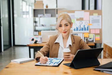 Serbest çalışan kadın tablet bilgisayar, muhasebe analizi, gayrimenkul yatırım verileri, modern ofis finansmanı üzerinde çalışıyor.