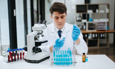 Modern tıbbi araştırma laboratuvarı. Bilimadamı mikro pipetlerle çalışıyor, biyokimyasal örnekleri analiz ediyor, tıp için ileri bilim kimya laboratuvarında çalışıyor..